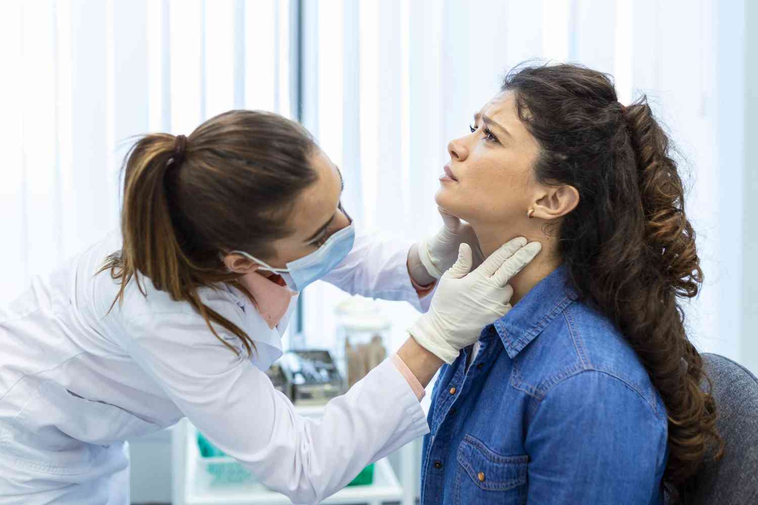 doctora examinando garganta de paciente femenina