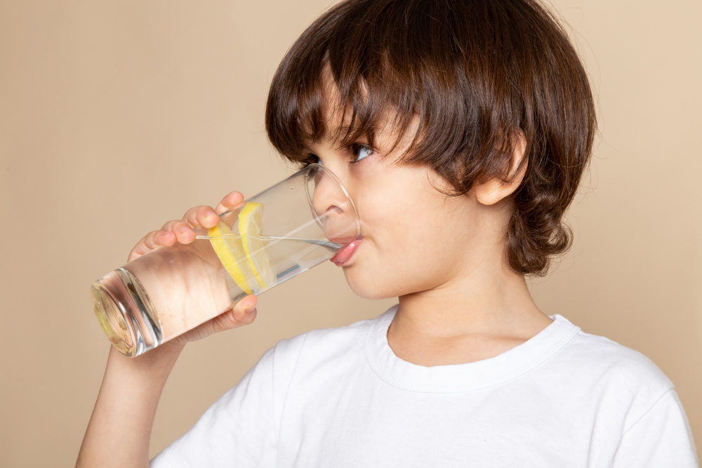 Niño bebiendo de un vaso de agua