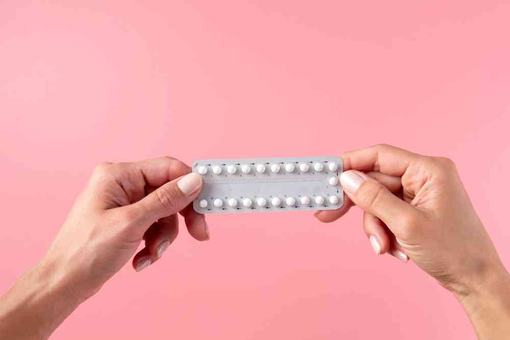 Anticonceptivos durante el ciclo menstrual - manos sosteniendo pildora anticonceptiva
