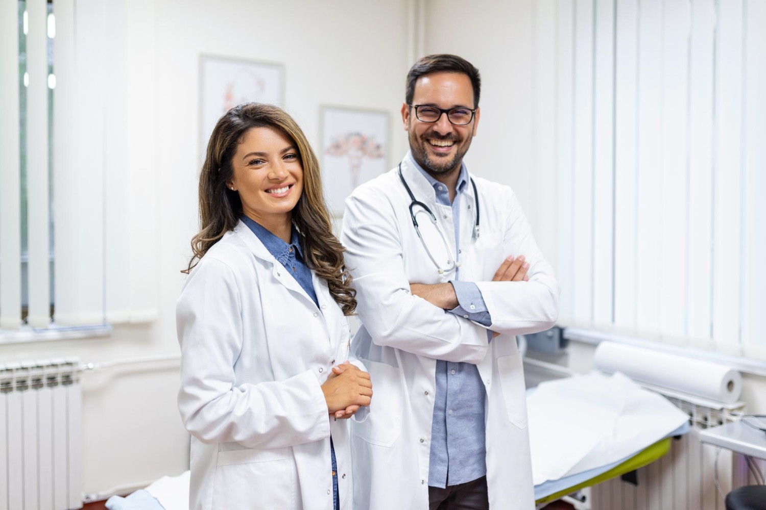 Doctores sonriendo hombre y mujer en sala de consulta