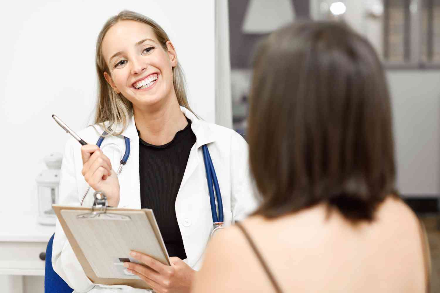 doctora mujer sonriendo con carpeta en la mano