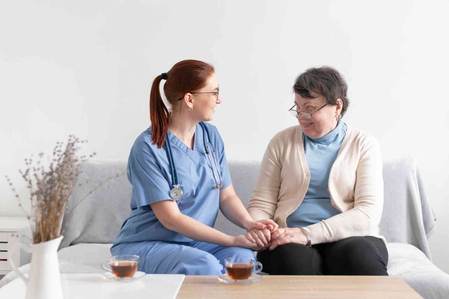 dos mujeres conversando una de mediana edad y otra enfermera adulta joven 